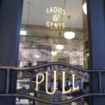 gilded metal sign with glass gilded entrance door