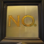 Harlem brownstone gilded signage with green shadow