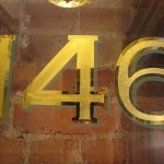 Harlem brownstone gilded signage with green shadow