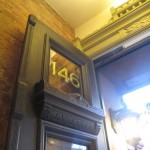 Harlem brownstone gilded signage with green shadow